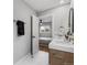 Bathroom featuring double sinks, wood cabinets and a view into the bright and airy bedroom at 3210 Magnolia St, Denver, CO 80207