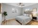 Bright bedroom with two windows, light hardwood floors, ceiling fan, and stylish gray headboard at 3210 Magnolia St, Denver, CO 80207
