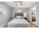 Comfortable bedroom featuring wood floors, a ceiling fan and a glimpse into the ensuite bathroom at 3210 Magnolia St, Denver, CO 80207