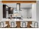 Modern kitchen features sleek black cabinets, stainless steel appliances, and a beautiful quartz countertop with bar stool seating at 3210 Magnolia St, Denver, CO 80207