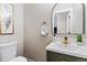 Elegant powder room featuring a toilet, floating sink and decorative mirror at 3210 Magnolia St, Denver, CO 80207