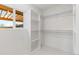 A spacious walk-in closet with built-in shelving and natural light filtering through a window at 3210 Magnolia St, Denver, CO 80207