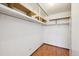 Walk in closet with custom shelves and wood floor at 660 S Alton Way # 3B, Denver, CO 80247