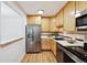 Bright kitchen with stainless steel fridge, wood cabinets and hard surface countertops at 660 S Alton Way # 3B, Denver, CO 80247