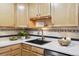 Bright kitchen with wood cabinets, undermounted lights, and hard surface countertops at 660 S Alton Way # 3B, Denver, CO 80247