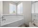 Bright bathroom with a large soaking tub and subway tile backsplash, illuminated by natural light at 5276 S Danube St, Centennial, CO 80015