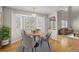 A bright dining area featuring a round table, modern chairs, bay windows, and a view into the living room at 5276 S Danube St, Centennial, CO 80015