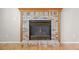 Close-up of the fireplace with a black frame and brick surround and a stained wood mantle at 5276 S Danube St, Centennial, CO 80015