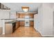 A view of a kitchen with wood floors, stainless appliances, and a view of the stairwell and other rooms in the home at 5276 S Danube St, Centennial, CO 80015