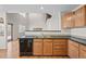 A view of a kitchen with wood floors, stainless appliances, and a view of the stairwell and other rooms in the home at 5276 S Danube St, Centennial, CO 80015