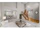 Stylishly furnished living room with an open floor plan connecting to a dining area and a wooden staircase at 5276 S Danube St, Centennial, CO 80015