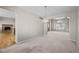 An inviting living room with neutral carpet, modern chandelier, and archway into another room featuring a cozy fireplace at 5276 S Danube St, Centennial, CO 80015
