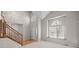 Bright and open living room featuring large windows, a wooden staircase, and seamless access to the entrance at 5276 S Danube St, Centennial, CO 80015