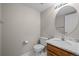 Powder room featuring a pedestal sink with a marble countertop and a round mirror at 5276 S Danube St, Centennial, CO 80015