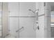 This renovated glass shower features white subway tile, a shower bench, and accessibility grab bars at 5276 S Danube St, Centennial, CO 80015