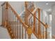 Close-up of an elegant staircase featuring wooden railings, carpeted steps, and hardwood flooring at 5276 S Danube St, Centennial, CO 80015