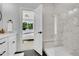 Elegant bathroom with marble shower, a modern white vanity and door to bedroom at 8530 W 52Nd Ave # A1, Arvada, CO 80002