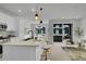 Open-concept kitchen with island seating, modern light fixtures, and stainless appliances at 8530 W 52Nd Ave # A1, Arvada, CO 80002