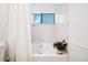 Bright bathroom featuring a white tiled shower-tub and a window for natural light at 12360 W Nevada Pl # 206, Lakewood, CO 80228