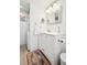 Charming bathroom features a white vanity, beadboard walls, and integrated in-unit washer and dryer at 12360 W Nevada Pl # 206, Lakewood, CO 80228