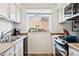 Well-lit kitchen featuring a stainless steel oven, overhead microwave, and tile backsplash at 12360 W Nevada Pl # 206, Lakewood, CO 80228