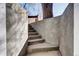 Concrete steps lead up from the backyard, enclosed by concrete walls and a tree at 1378 Forest St, Denver, CO 80220