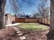 Backyard view with patio stones, lawn, privacy fence, trees and brick building at 1378 Forest St, Denver, CO 80220