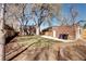 Backyard featuring large, mature trees, a lawn, and a brick garage at 1378 Forest St, Denver, CO 80220
