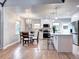 Bright dining area with hardwood floors, a chandelier, and an adjacent modern kitchen at 1378 Forest St, Denver, CO 80220