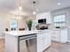Bright kitchen with a large island featuring a dishwasher, quartz countertops, and stainless steel appliances at 1378 Forest St, Denver, CO 80220