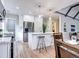 Open-concept kitchen featuring an island with seating, stainless steel appliances, and hardwood floors at 1378 Forest St, Denver, CO 80220