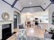Open-concept living room featuring vaulted ceilings, a fireplace, and views into the dining and kitchen areas at 1378 Forest St, Denver, CO 80220