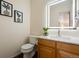 Modern bathroom with illuminated mirror, stylish decor, and wood vanity at 11248 W Ford Dr, Lakewood, CO 80226