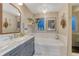Elegant bathroom featuring a marble countertop, gray vanity, soaking tub, and stylish decor accents at 13053 Umatilla Ct, Denver, CO 80234
