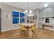 Bright dining area with hardwood floors, gray walls, and a large window at 13053 Umatilla Ct, Denver, CO 80234