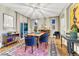 Dining room featuring a wooden table, blue chairs, a colorful rug, and sliding glass doors at 13053 Umatilla Ct, Denver, CO 80234