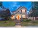 Inviting two-story home with a manicured lawn, orange front door, and charming architectural details at 13053 Umatilla Ct, Denver, CO 80234