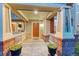 Close-up of a welcoming covered front porch with brick accents and a vibrant orange front door at 13053 Umatilla Ct, Denver, CO 80234