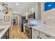 Kitchen with stainless steel appliances, gray cabinets, white countertops, and hardwood floors at 13053 Umatilla Ct, Denver, CO 80234