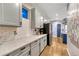 Modern kitchen with white cabinets, stainless steel appliances, quartz countertops, and hardwood floors at 13053 Umatilla Ct, Denver, CO 80234
