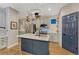 Bright kitchen features a center island with a sink, pot rack, and stainless steel appliances at 13053 Umatilla Ct, Denver, CO 80234