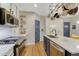 Well-lit kitchen featuring stainless steel appliances, an island with a sink, and hanging pot rack at 13053 Umatilla Ct, Denver, CO 80234