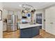 Kitchen with stainless steel refrigerator and microwave, light gray cabinets, and hardwood flooring at 13053 Umatilla Ct, Denver, CO 80234