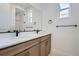 Bright bathroom featuring dual sinks with quartz countertops and wooden cabinets at 910 Promenade Dr, Superior, CO 80027