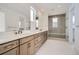 Bathroom featuring dual sink vanities and a tiled shower with a glass door at 910 Promenade Dr, Superior, CO 80027
