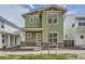Charming two-story home with green siding, large windows, and well-manicured lawn at 910 Promenade Dr, Superior, CO 80027