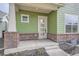 Welcoming covered front porch with brick pillars and a modern front door at 910 Promenade Dr, Superior, CO 80027