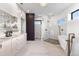 Bright bathroom features a large double sink vanity, modern tub, glass shower, and neutral color palette at 8240 W Tennessee Ave, Lakewood, CO 80226