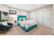 Cozy bedroom featuring a plush blue bed with a comfortable accent chair and soft carpeting at 8240 W Tennessee Ave, Lakewood, CO 80226