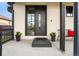 Stylish front entrance showcasing a modern wooden door with a glass panel, complemented by potted plants at 8240 W Tennessee Ave, Lakewood, CO 80226